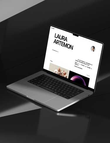 A laptop computer on a desk displaying the Laura.art website.