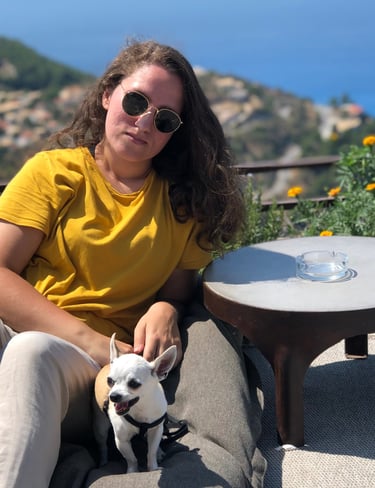 Portrait of Vassianna with her first dog, a chihuahua, sitting outdoors.
