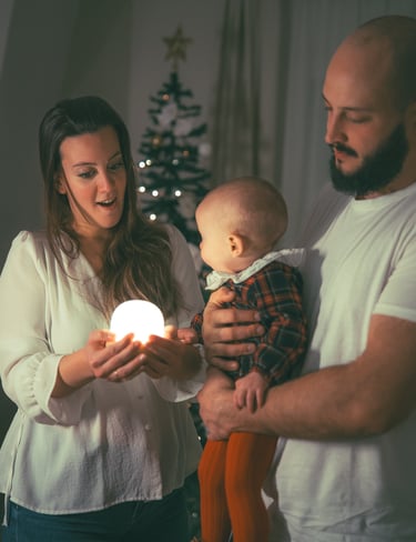 sesion fotografia de una familia en su casa en navidad jugando con una luz