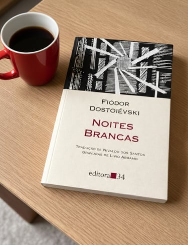 Portuguese edition of White Nights by Fyodor Dostoevsky on a wooden table next to a red coffee mug.