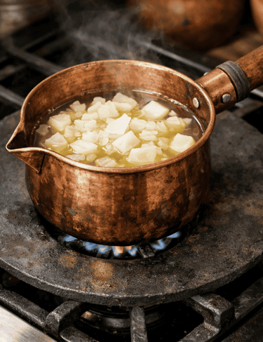 cera derritiéndose en cazo de cobre sobre un comal