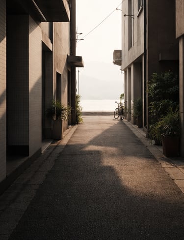 Quiet alley with sunlight, shadows, and water visible in the distance