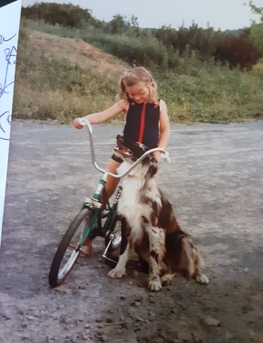 Image of girl on bike with a dog.
