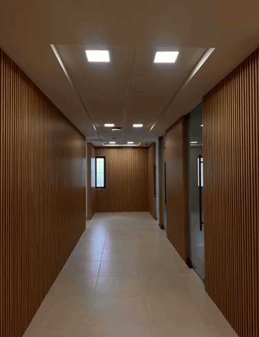 Pasillo con acabado de madera en muros y plafón con luminarias LED | KARÄNA
