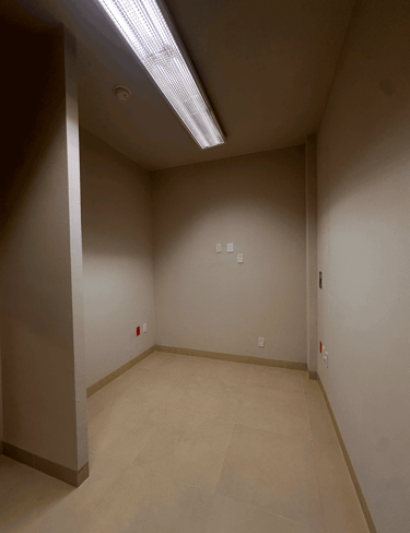 Cuarto vacío con muros beige y luminaria LED central en plafón | KARÄNA