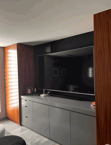 Mueble de TV moderno en acabado gris, con paneles verticales de madera y pared acentuada | KARÄNA