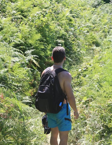 a man walking down a path with a backpack