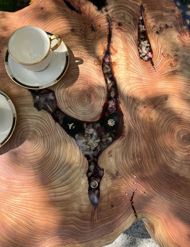 live edge epoxy tables with charms and flowers filling in the gaps where the bark used to be