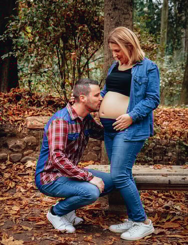 pareja dando un beso en la barriga embarazada de la madre