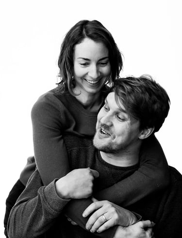 A married couple laughing during a portrait shoot.