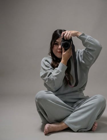 Fotográfa sentada sobre el piso con las piernas cruzadas