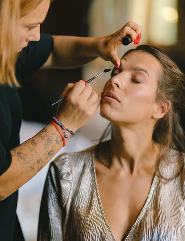 une femme se fait maquiller par une maquilleuse professionnelle