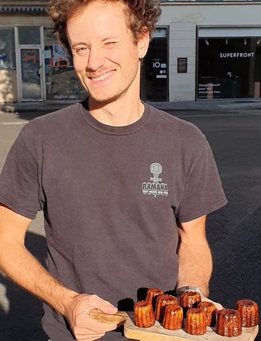 Un homme tient une planche avec des cannelés dessus