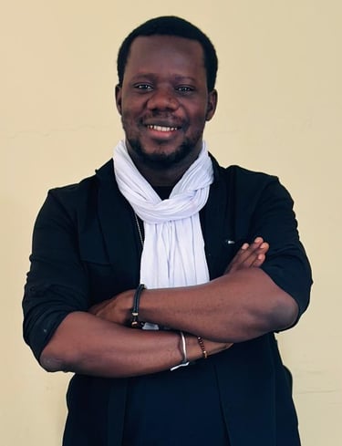 a man in a suit and scarf standing in front of a wall