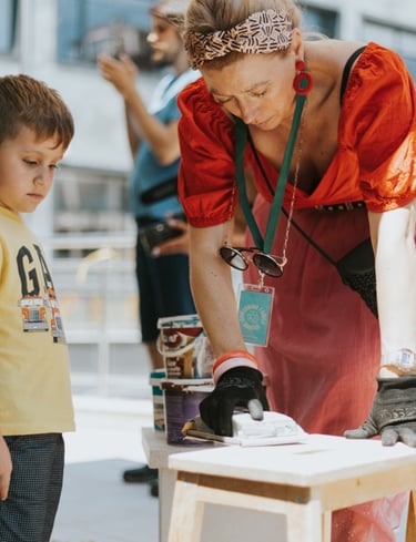 a woman in a red dress is standing in front of a table with a child