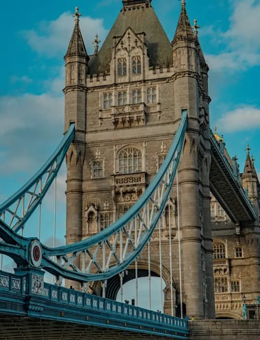 Close-up of the historic Tower Bridge in London featuring blue suspension cables and gothic stone architecture.