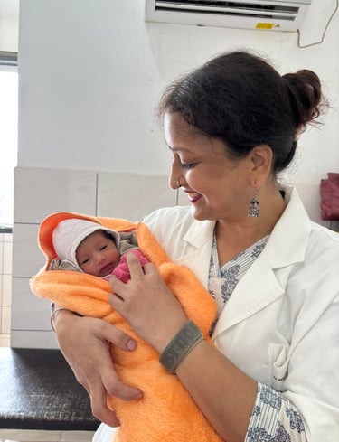 Dr. Renu Agrawal Rini Hospital Dholpur, a woman in a white coat holding a baby in a Hospital