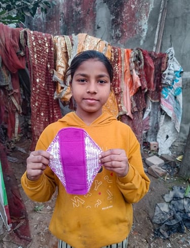 Young girl holding up a Hanaru reusable sanitary napkin