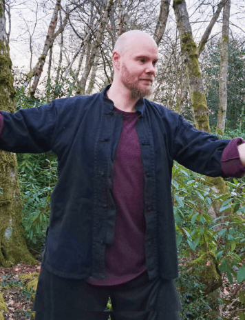 male tai chi teacher practicing outdoors in nature