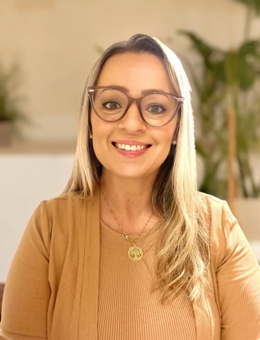 mulher loira de óculos e com um colar dourado sorrindo