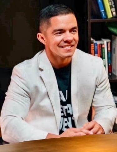 Cody Sechelski smiling in a white jacket, representing transformation from adversity to purpose-driven leadership