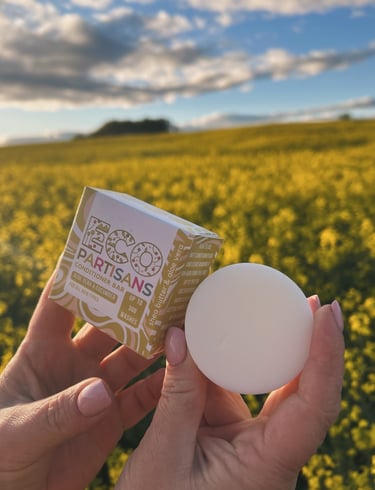 a person holding a soap bar in front of a field