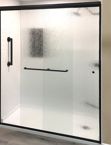 Frosted glass shower with black hardware installed by Toledo New Bath.