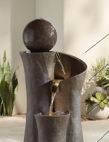 Modern outdoor tier stone water fountain with a bubbling sphere and cascading falls.