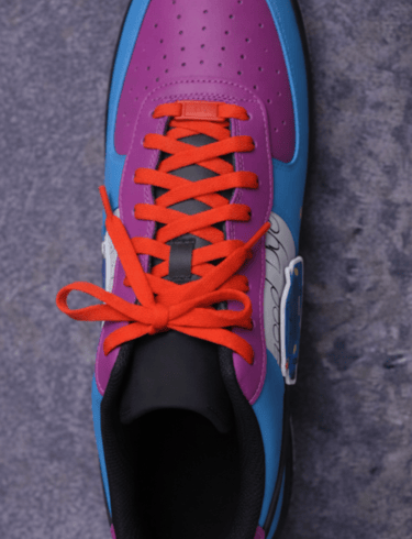 a pair of sneakers with orange laces and red laces