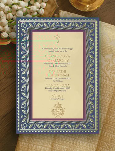 a wedding invitation card with a gold frame and a blue and white floral arrangement