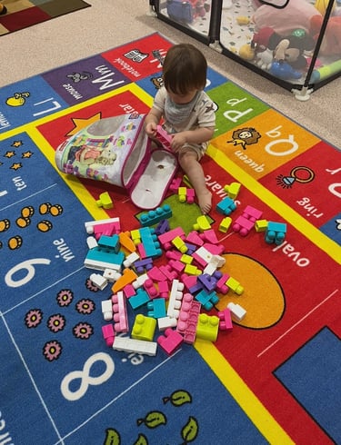 Young boy playing with multi-colored toy blocks