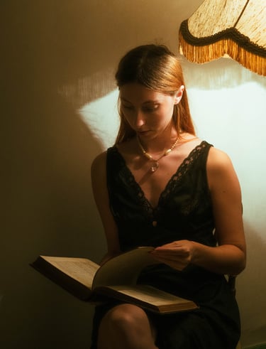 Autoportrait d'une femme avec un livre dans la pénombre