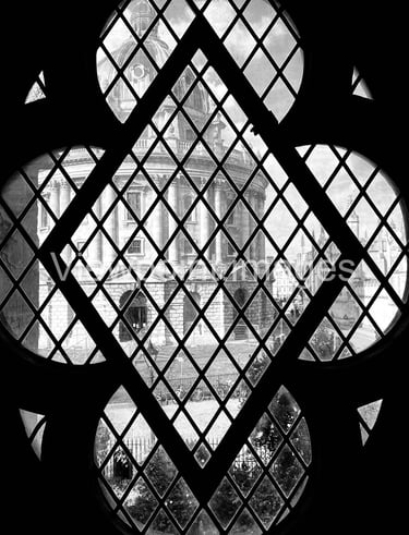 Black and white view of the Radcliffe Camera in Oxford through a gothic quatrefoil window.