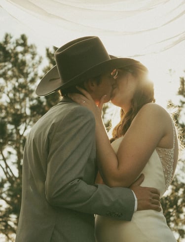 bride and groom portrait, kissing, sunlight