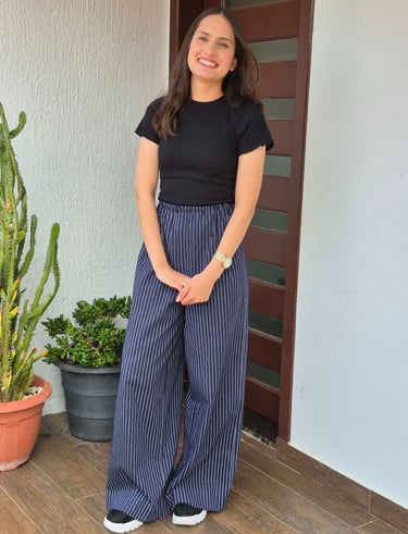 Mulher em pé uma calça azul marinho com estampa risca de giz