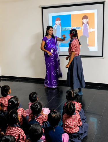 Teacher conducting an interactive smart classroom session with primary school students at Little Cub