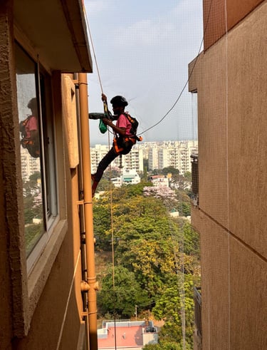 Wide shot of a Chennai apartment balcony fully secured with a neatly installed pigeon net.