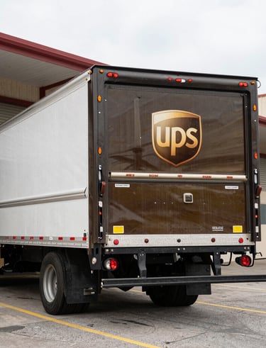 Friendly staff assisting a customer at the shipping counter filled with packages.