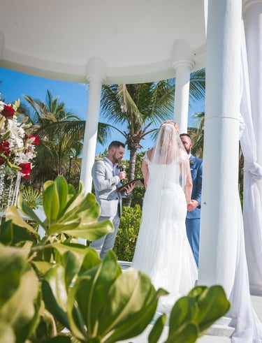 a bride and groom standing in front of a gazeboar