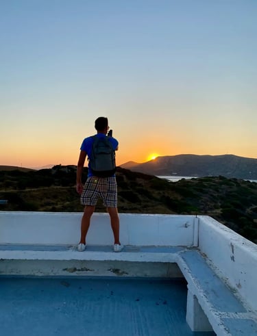 a man with a camera taking shots on sunset on white balcony