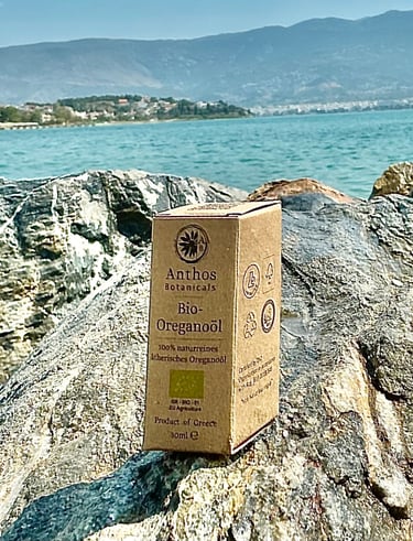a box of oregano essential oil sitting on a rock