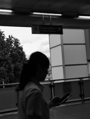 a woman walking down a walkway with a cell phone