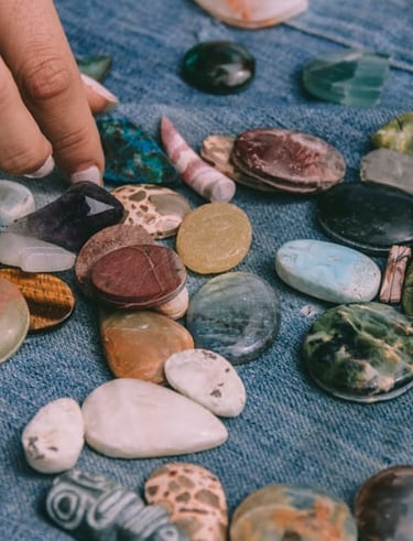 Una persona eligiendo piedras semipreciosas pulidas y cristales energéticos.