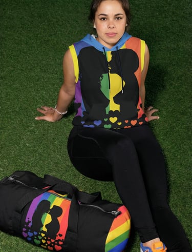 a woman sitting on the grass with gym bag and sleeveless hoodie with silhouettes of lesbian kissing