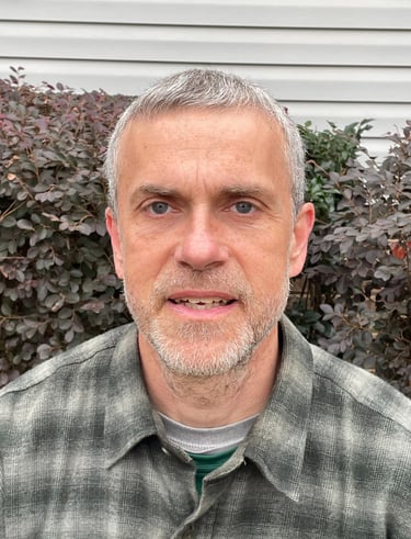 Arthur, the owner wearing a gray-green flannel shirt.