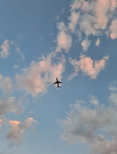 a plane flying through the sky with clouds