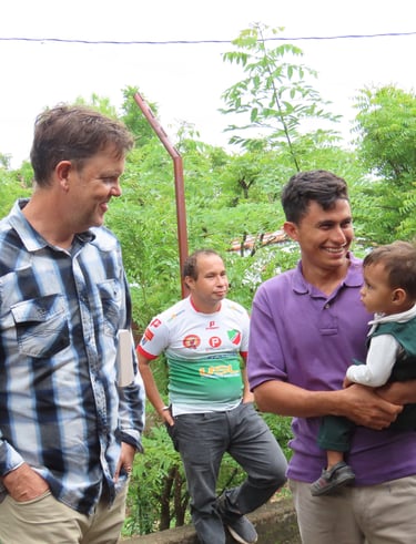 A man holds a baby, while another looks one smiling