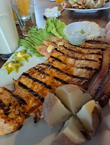 Plato típico colombiano servido en Parrilla y Vinos Juan Esteban, con carne asada al carbón, papas