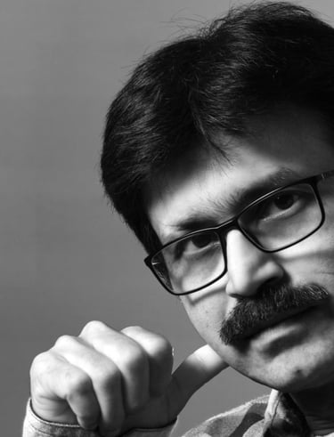 A close-up of a mane wearing specs and muoustache.