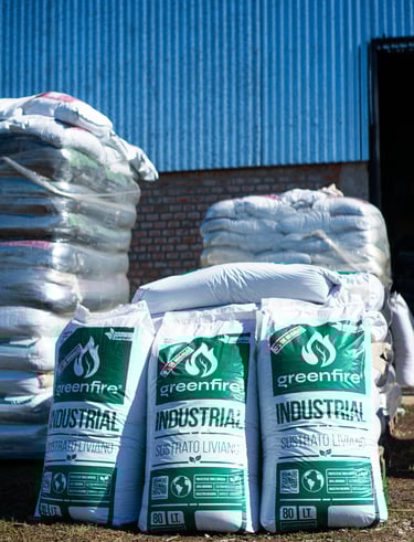 una pila de bolsas de sustrato frente a un galpón